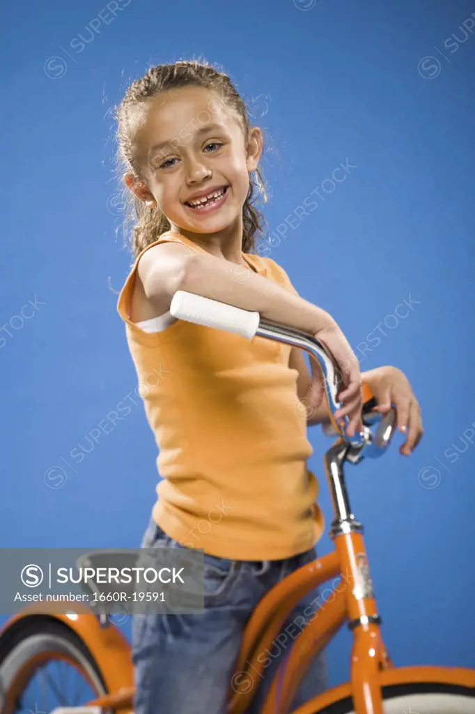 Girl on orange bicycle smiling