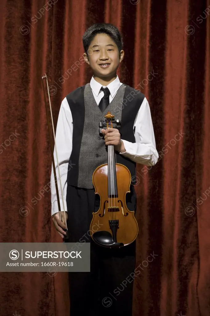 Boy with violin and bow smiling