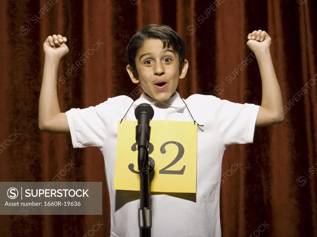 Boy contestant standing at microphone cheering