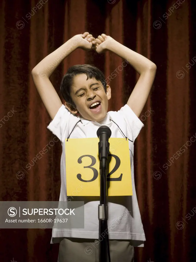 Boy contestant standing at microphone cheering