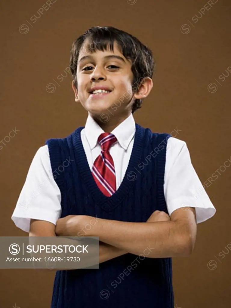 Boy standing with arms crossed smiling