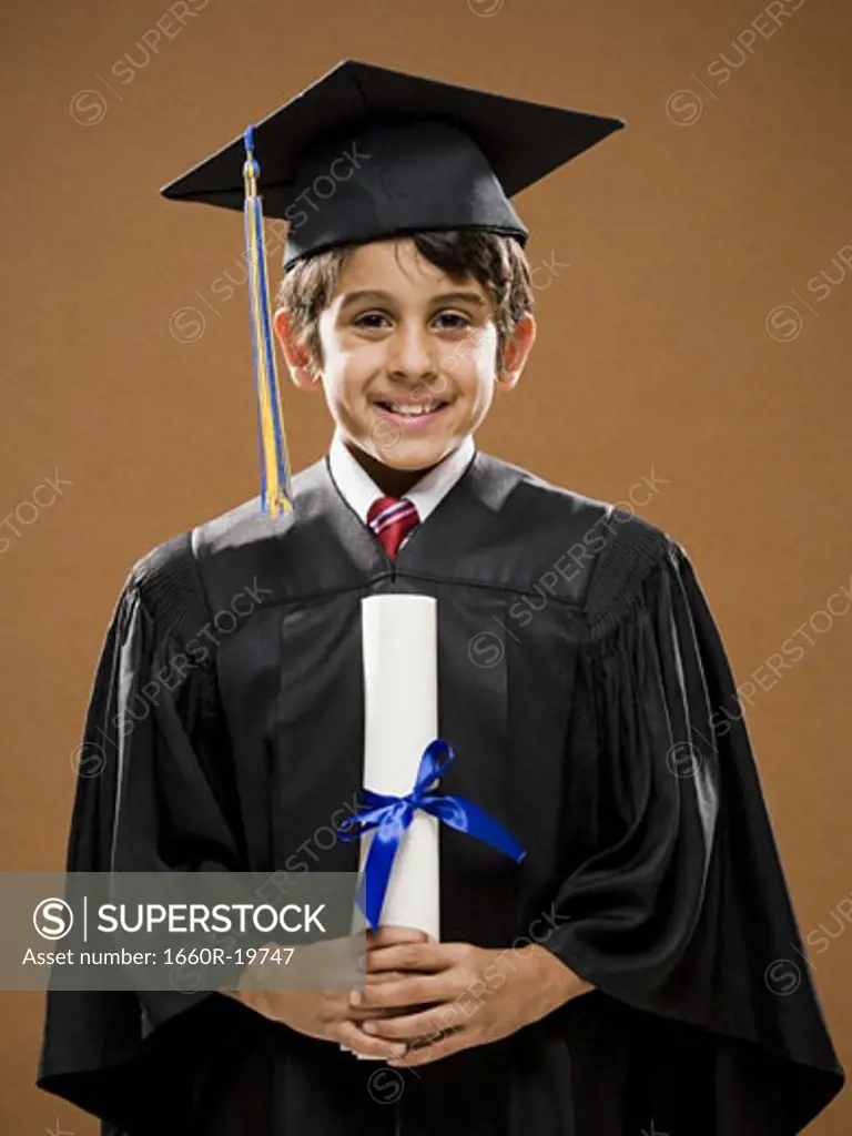 Boy graduate with mortar board and diploma smiling