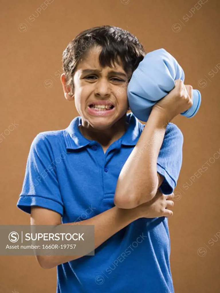 Boy holding ice pack to head