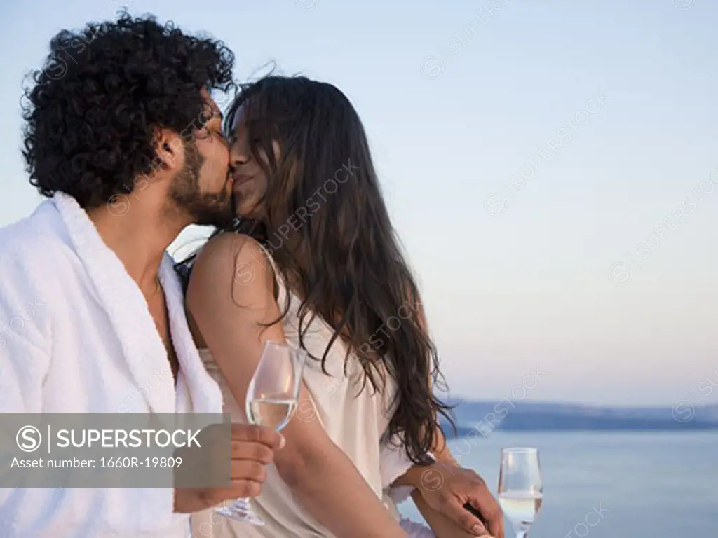 Couple kissing outdoors with champagne flutes