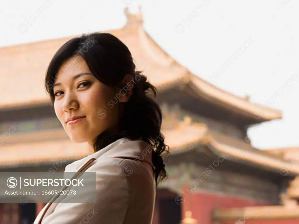 Businesswoman smiling outdoors with pagoda in background