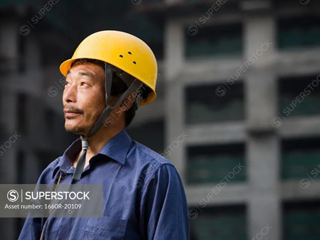 Construction worker with helmet outdoors looking up