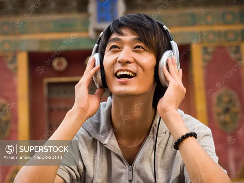 Teenage boy outdoors with headphones smiling