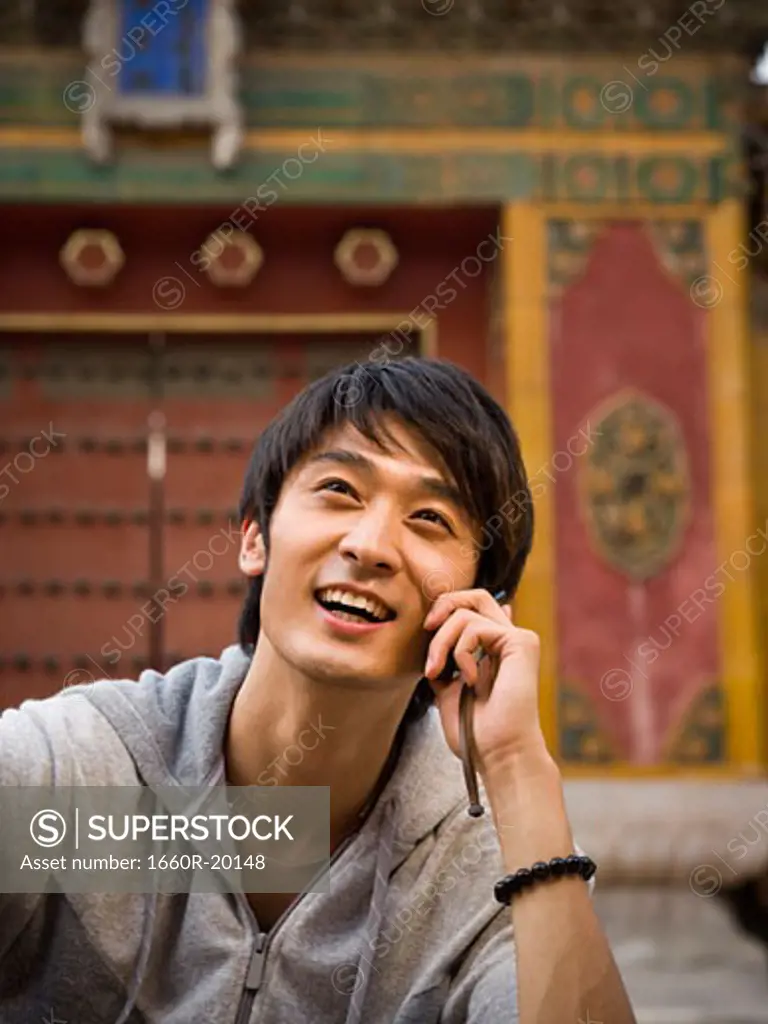 Teenage boy outdoors with cell phone smiling