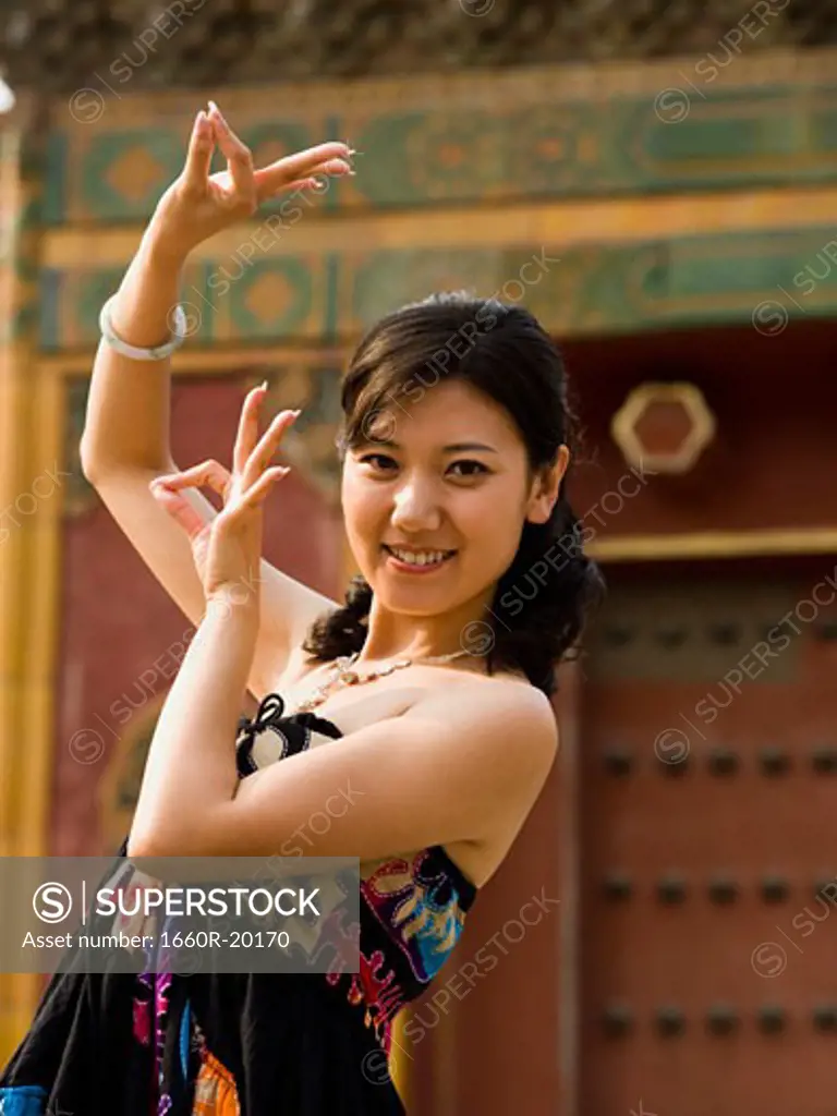 Woman doing tai chi outdoors smiling