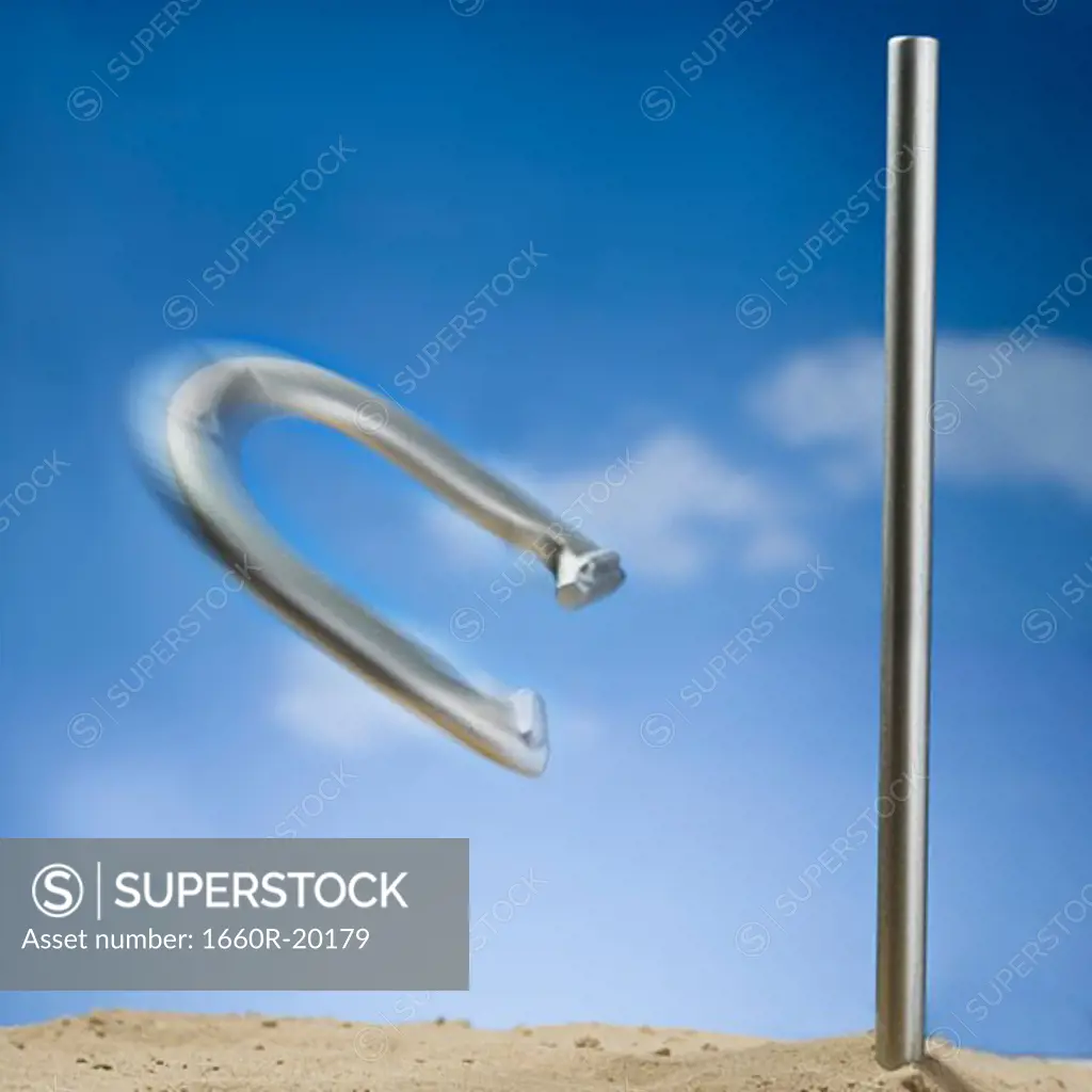 Horseshoe and peg with motion blur and blue sky
