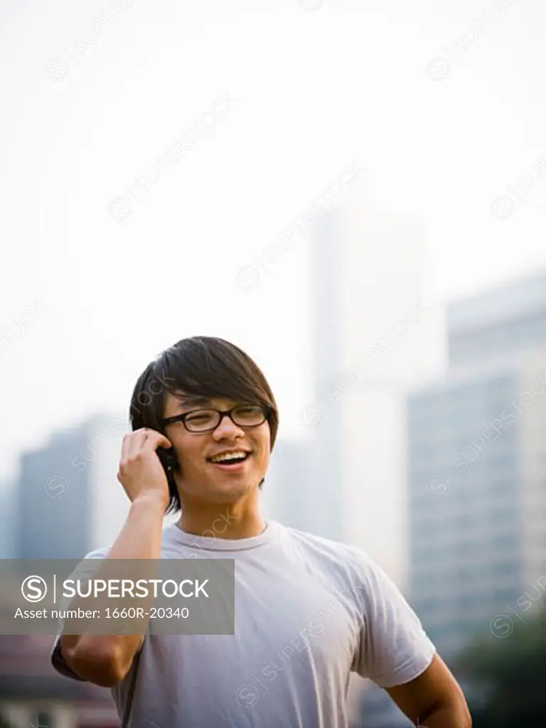 Man with eyeglasses talking on cell phone outdoors smiling