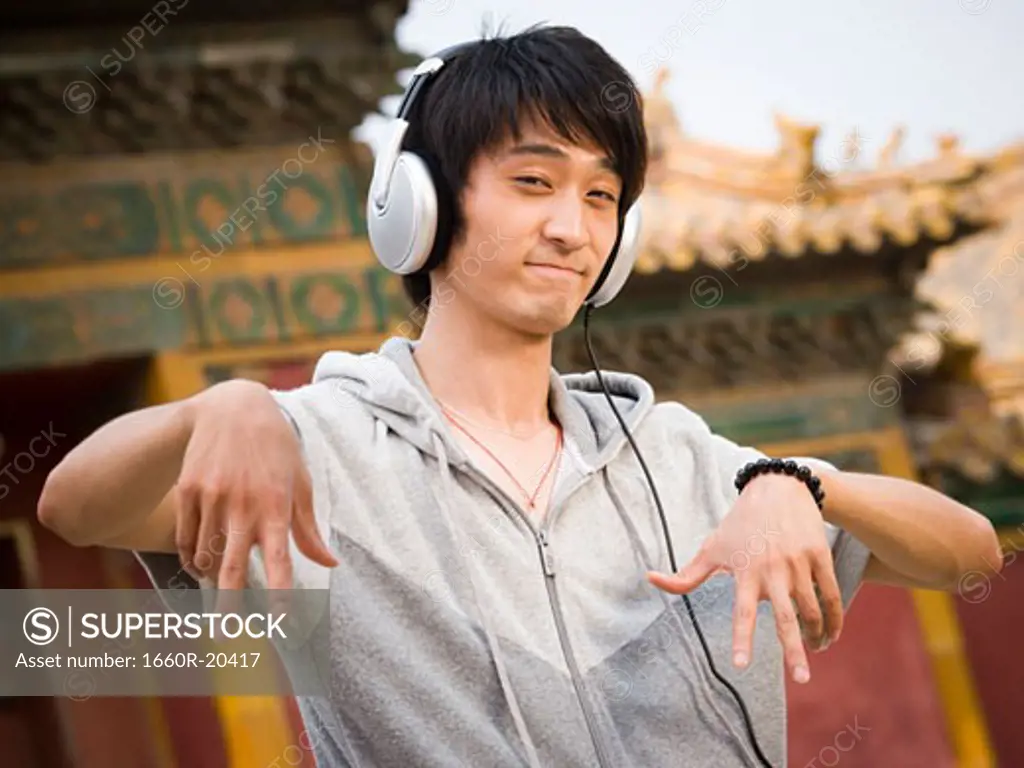 Teenage boy outdoors with headphones dancing
