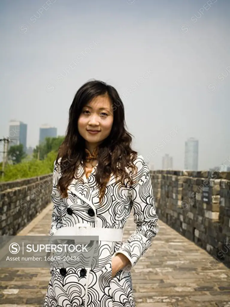 Woman standing on stone bridge smiling
