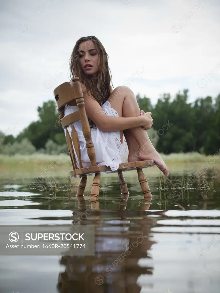 USA, Utah, Provo, woman sitting on chair in lake