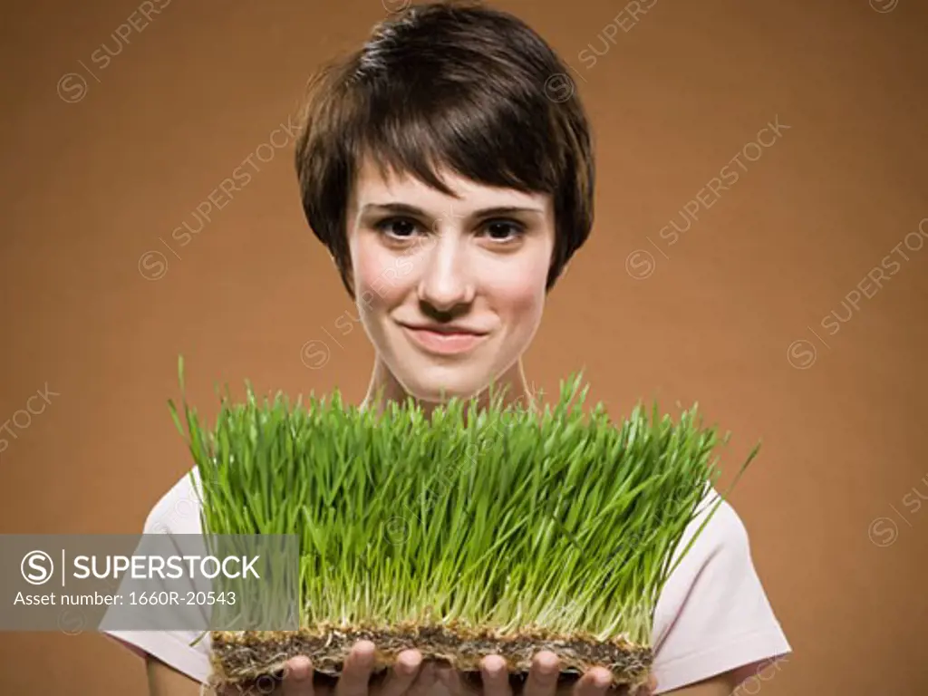 Woman holding grass and smiling