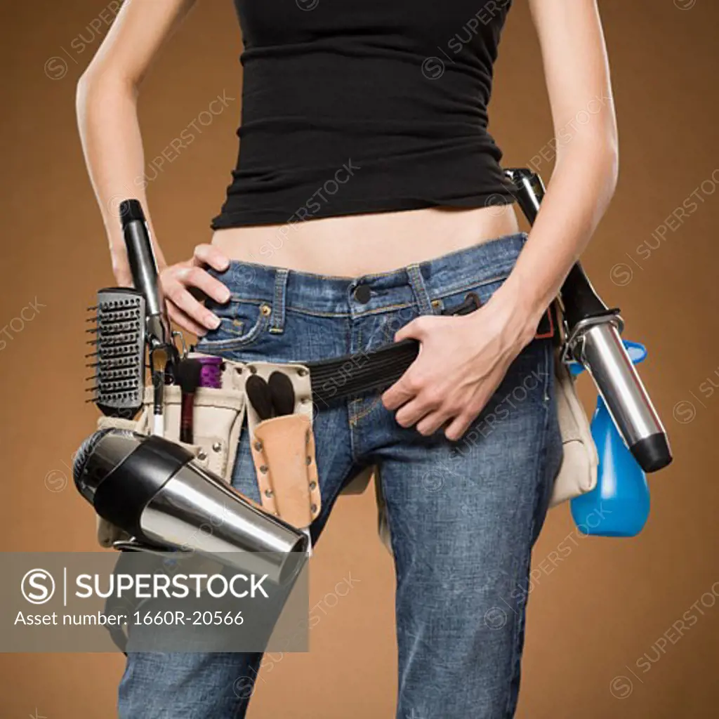 Mid section view of hairdresser with tool belt