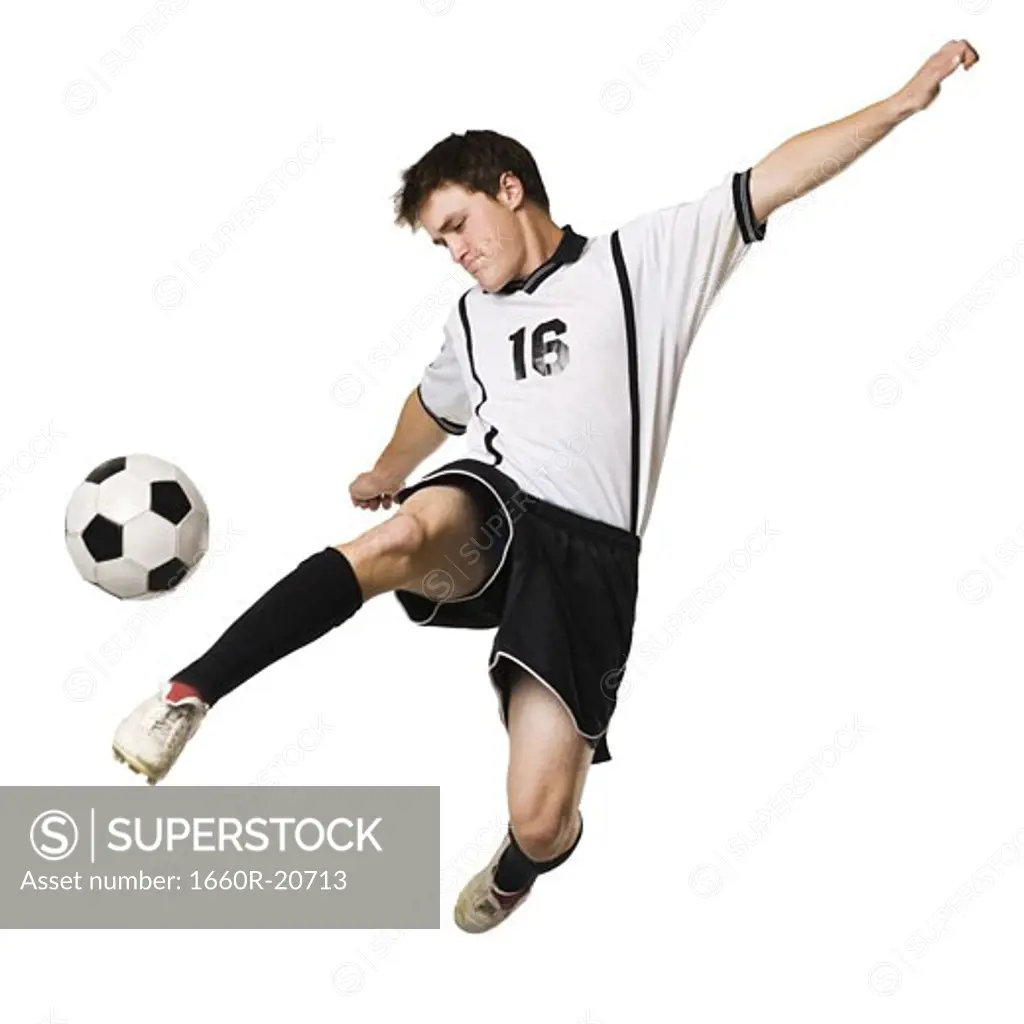 Young man kicking a soccer ball.