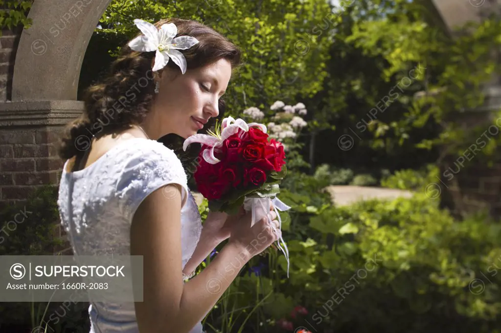 Side profile of a young woman smelling flowers