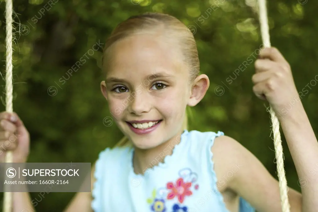 Portrait of a girl swinging on a swing