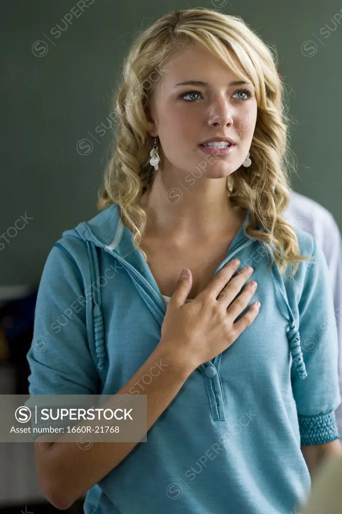 Young woman with hand over heart.