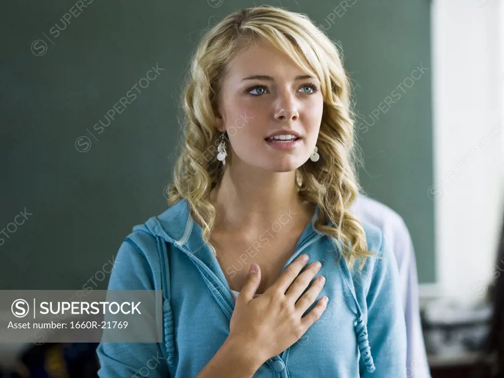 Young woman with hand over heart.