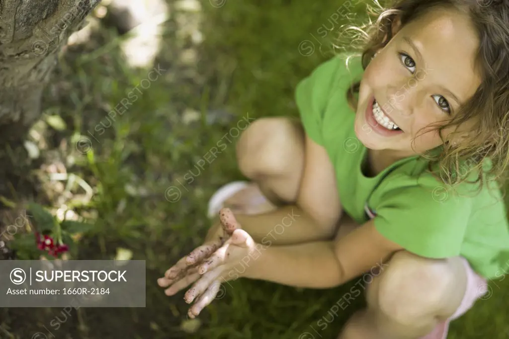 Portrait of a girl playing with mud