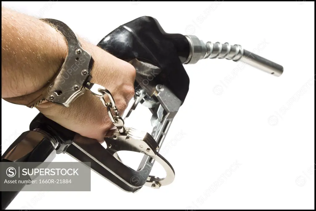 Hand handcuffed to a gas pump.