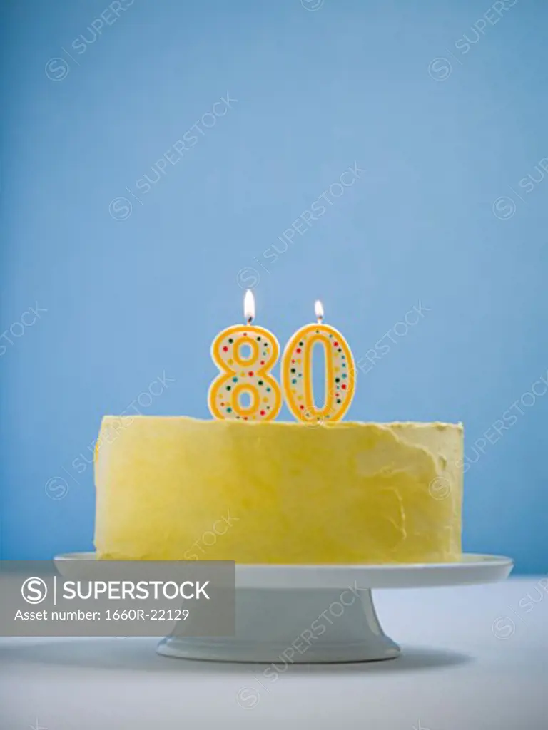 white cake on a platter with candles.