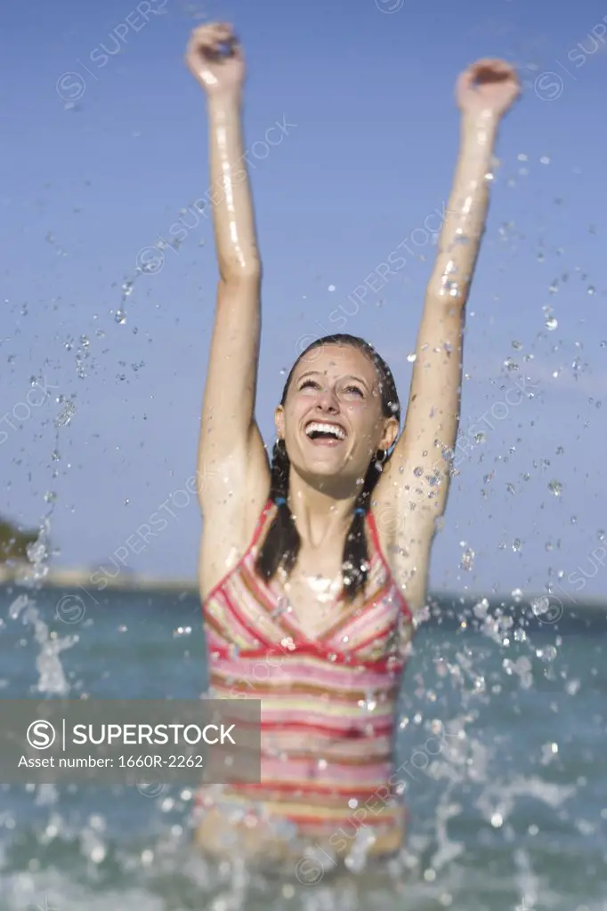 Teenage girl splashing water in the sea