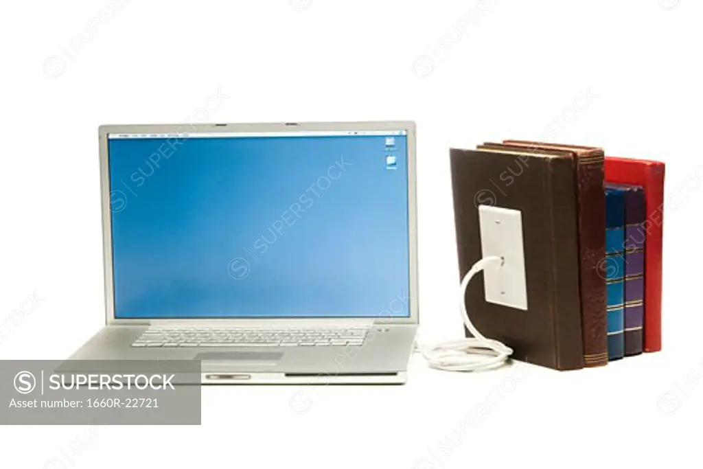 notebook computer plugged into books