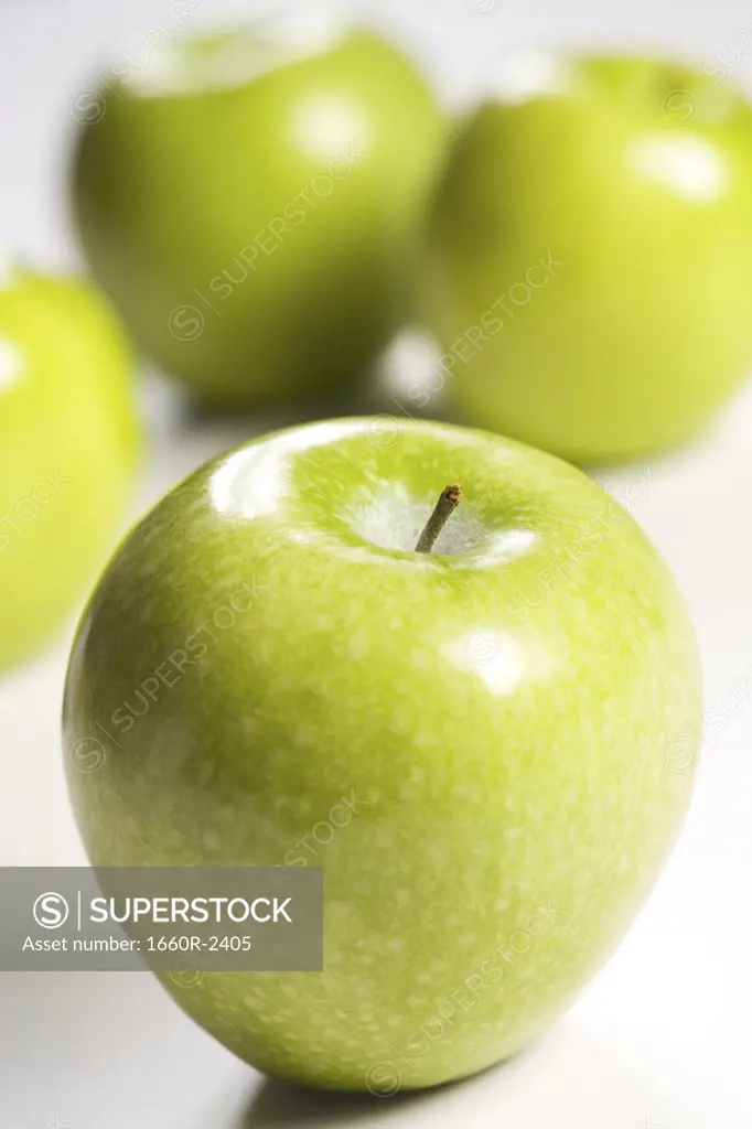 Close-up of four granny smith apples (aphis pomi)