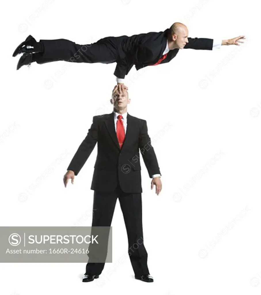 Two male acrobats in business suits performing