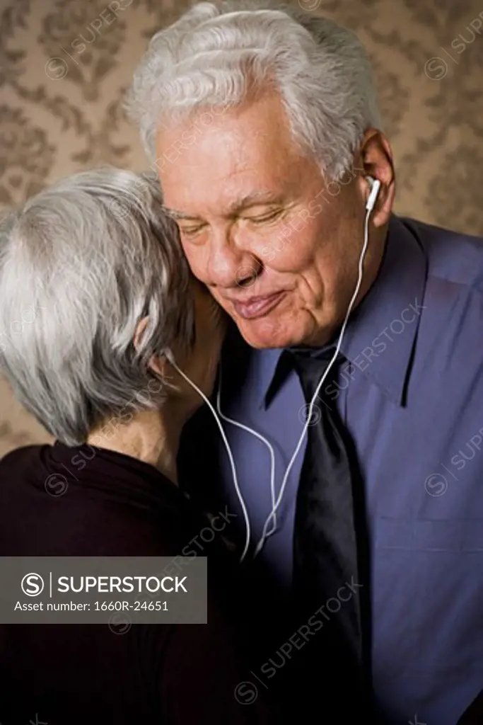 Profile of an elderly couple dancing and listening to music