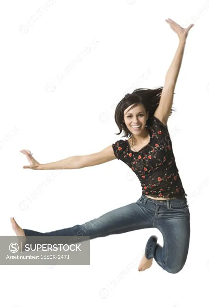 Portrait of a young woman jumping with her hand raised