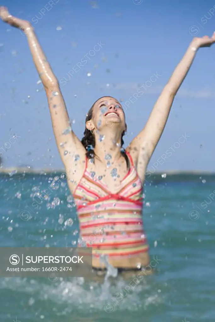 Young woman splashing water in the sea