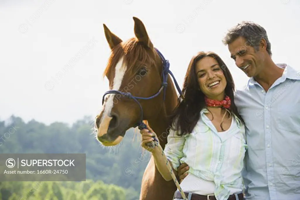 Portrait of a man and a  woman standing with a horse
