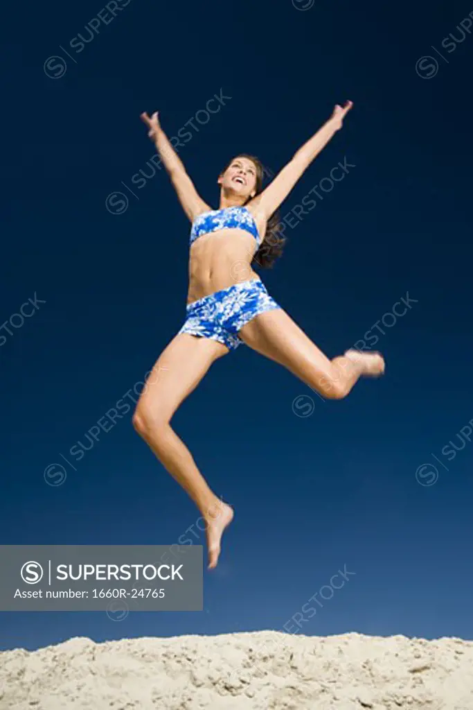 A young woman jumping at the beach