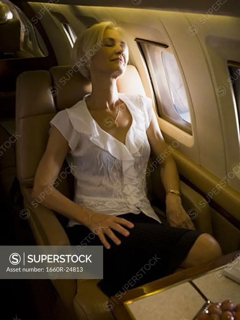 A senior woman sleeping in an airplane