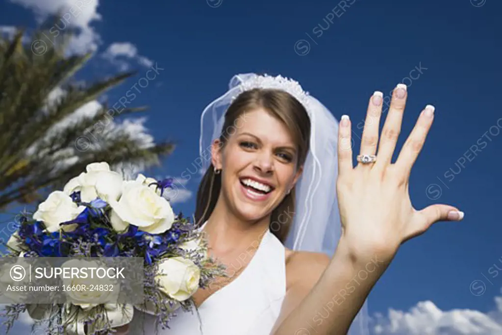 Portrait of a bride showing her wedding ring and smiling