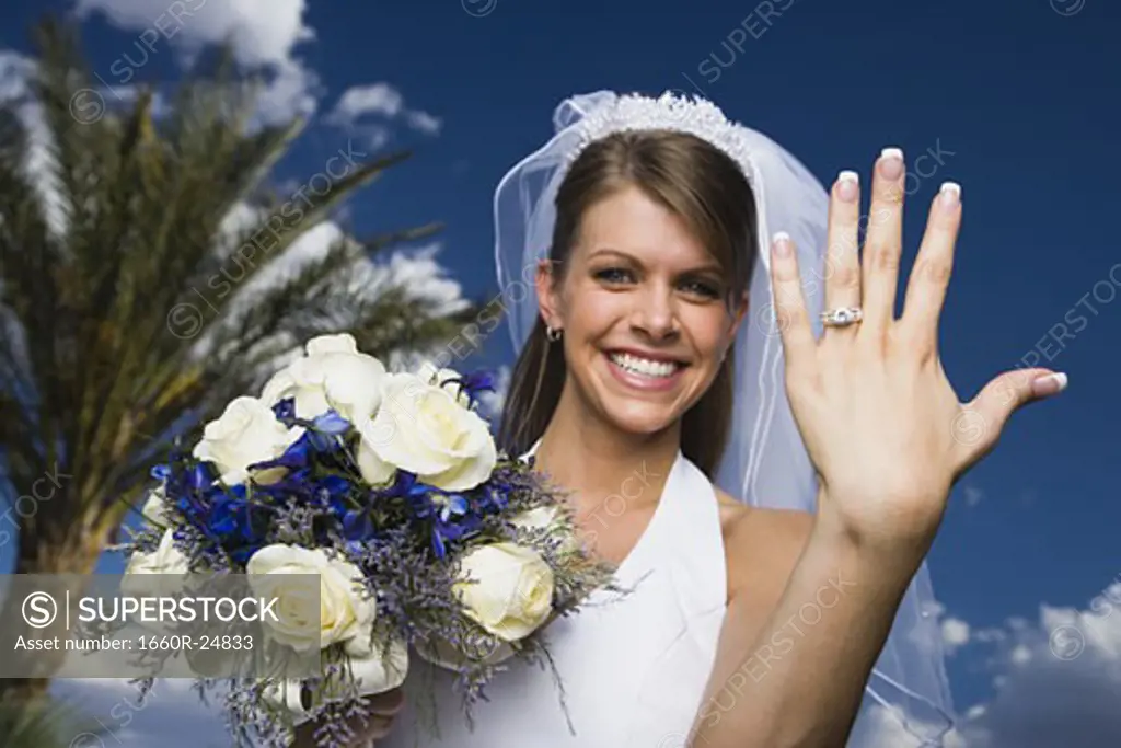 Portrait of a bride showing her wedding ring and smiling