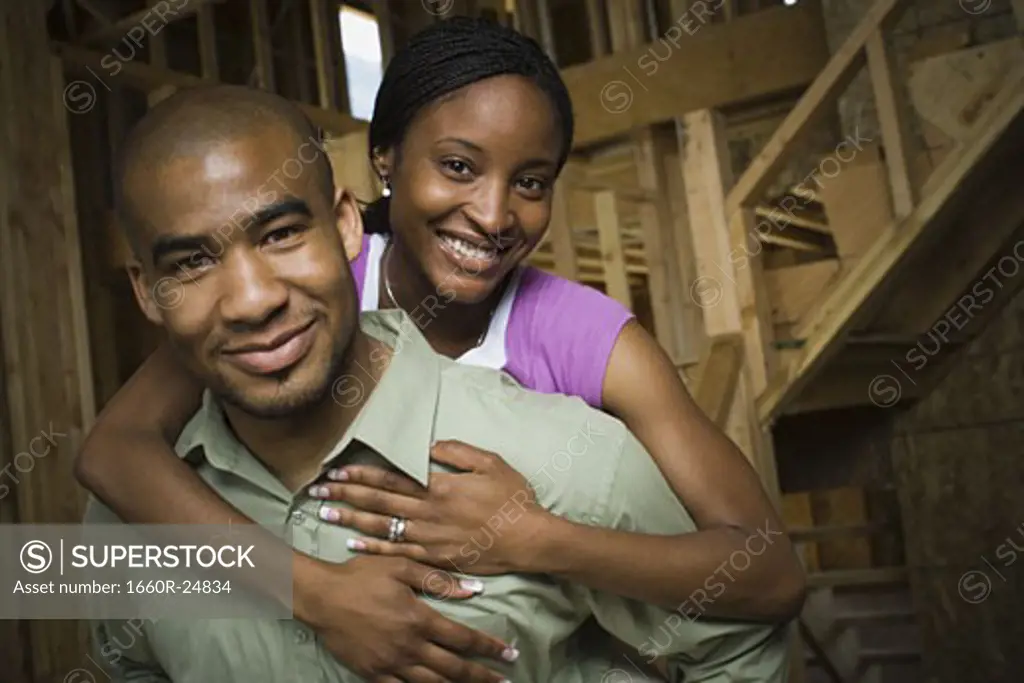 Portrait of a young adult couple in a house that is under construction