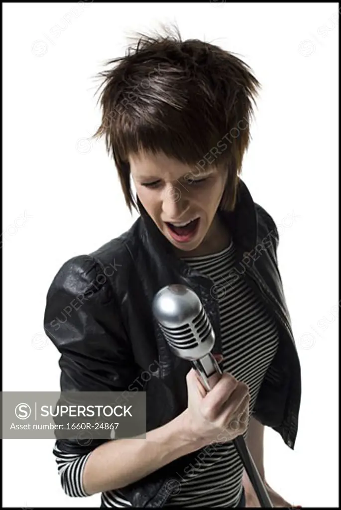 A young woman singing into a microphone