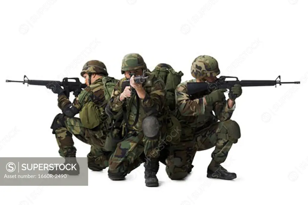 Three soldiers crouching and aiming their rifles
