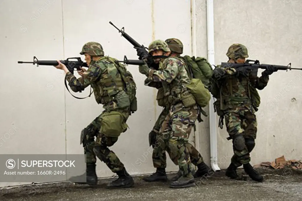 Four soldiers aiming their rifles