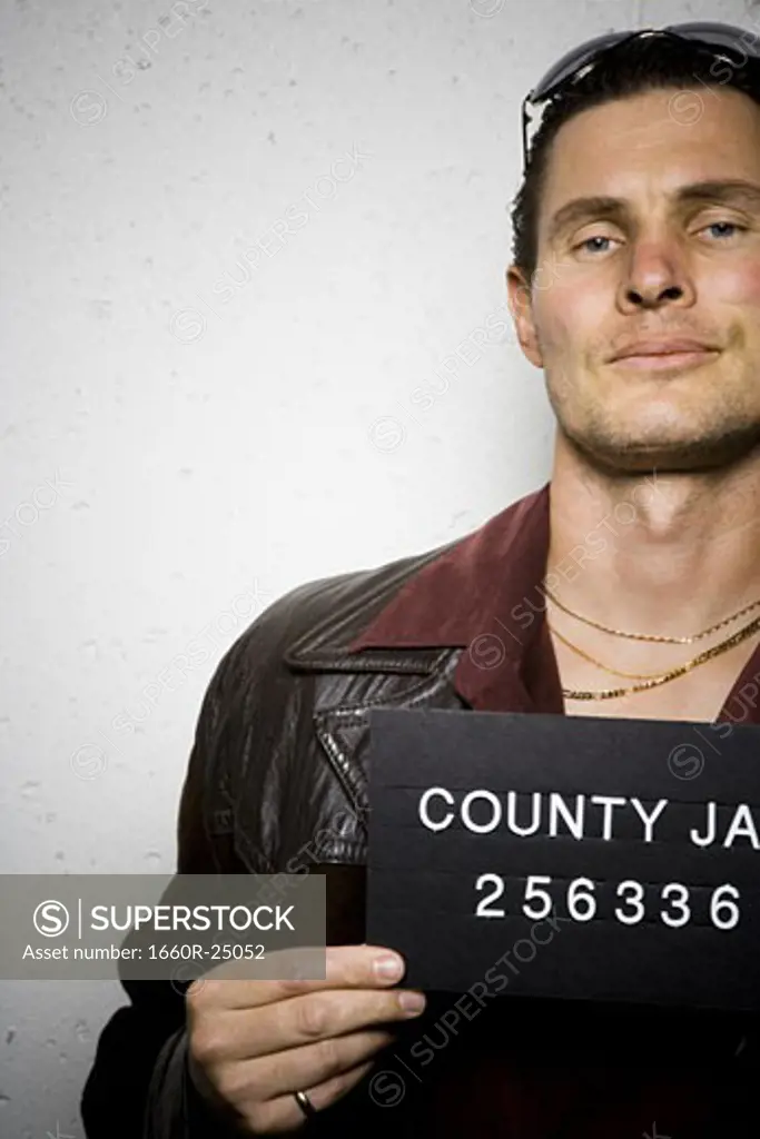 Mug shot of man with cigarette and gold chains