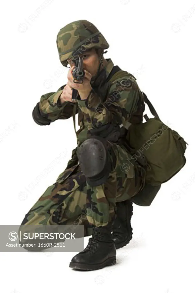 Portrait of a soldier crouching and aiming his rifle