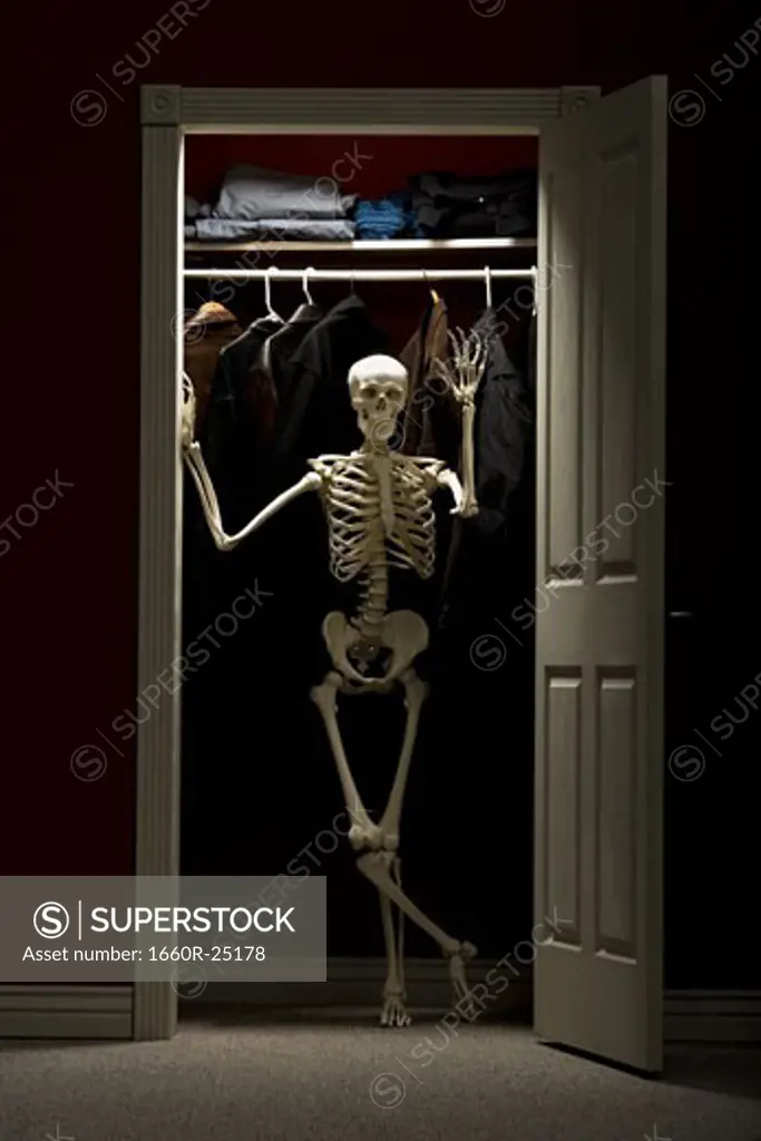Skeleton standing in closet waving