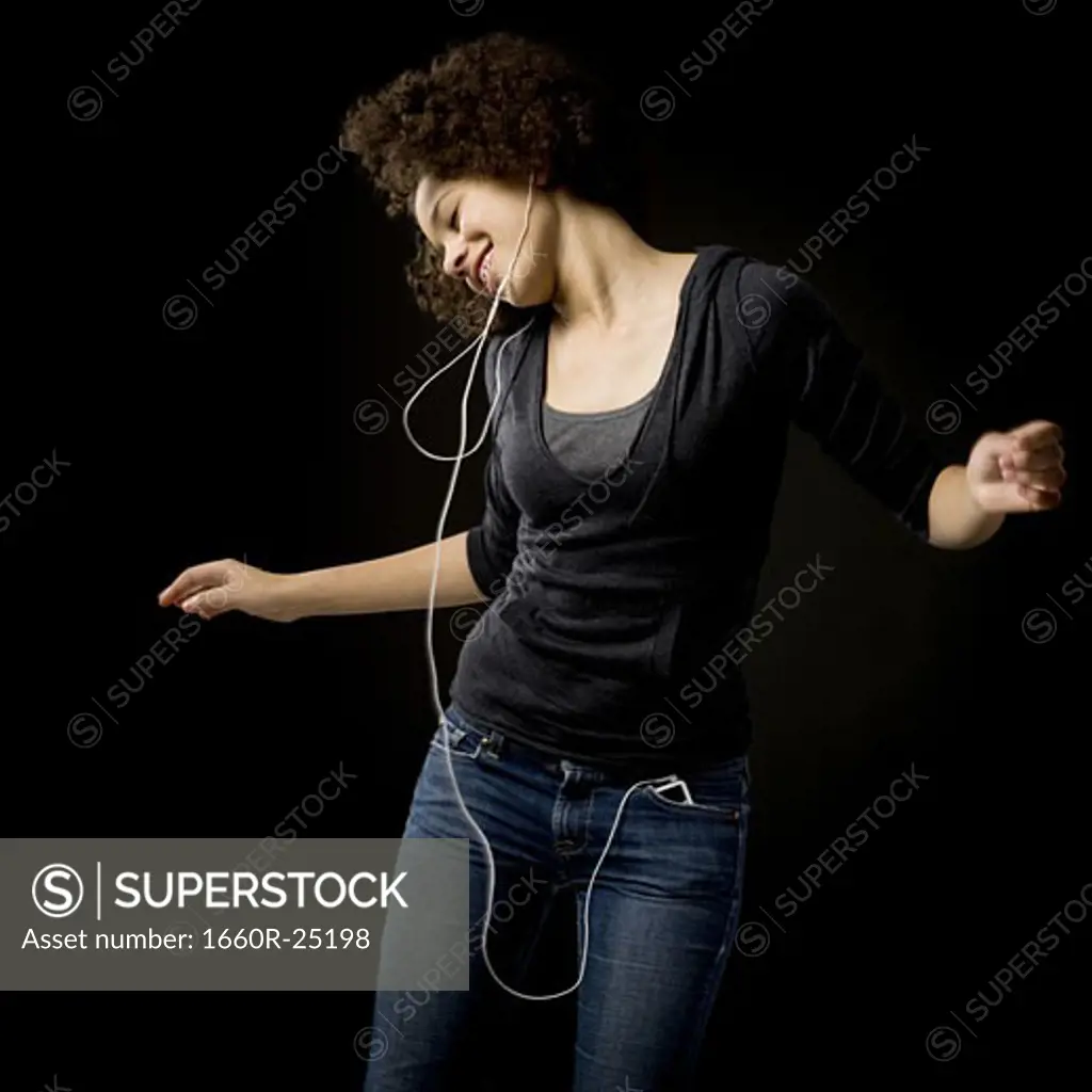 Girl with braces and MP3 player dancing and smiling