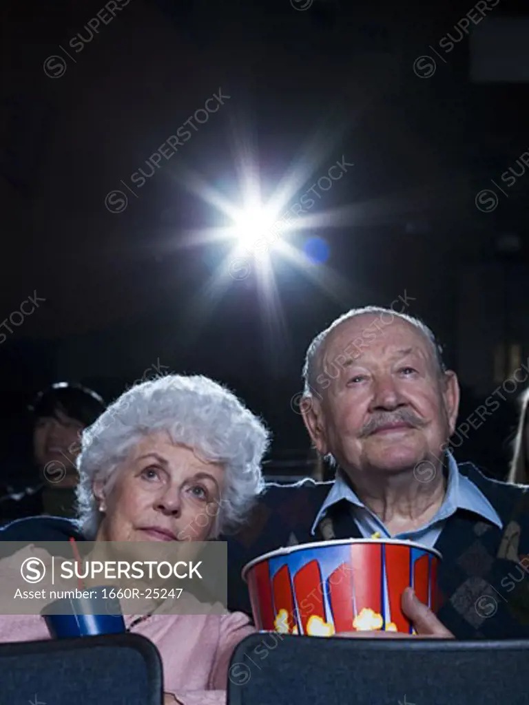 Man and woman watching movie with popcorn