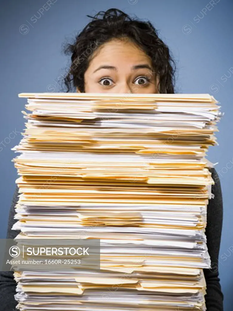 Woman holding stacks of paperwork
